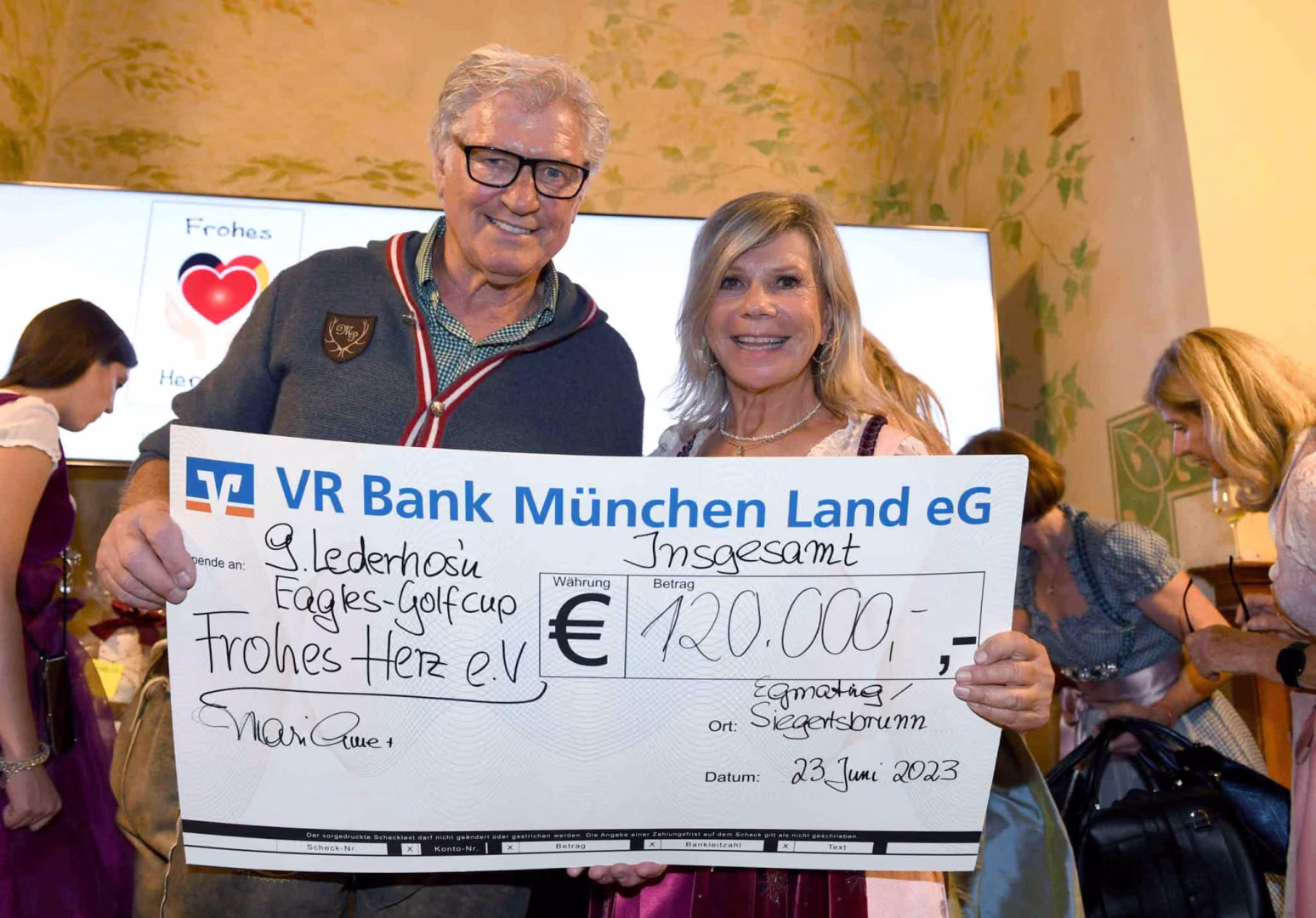 Marianne und Michael Hartl mit ihrem Gesamt-Spendenscheck / 9. Marianne und Michael – Lederhos’n – Cup 2023 zu Gunsten von „Frohes Herz“ e.V. / Foto: Wolfgang Breiteneicher/Schneider-Press